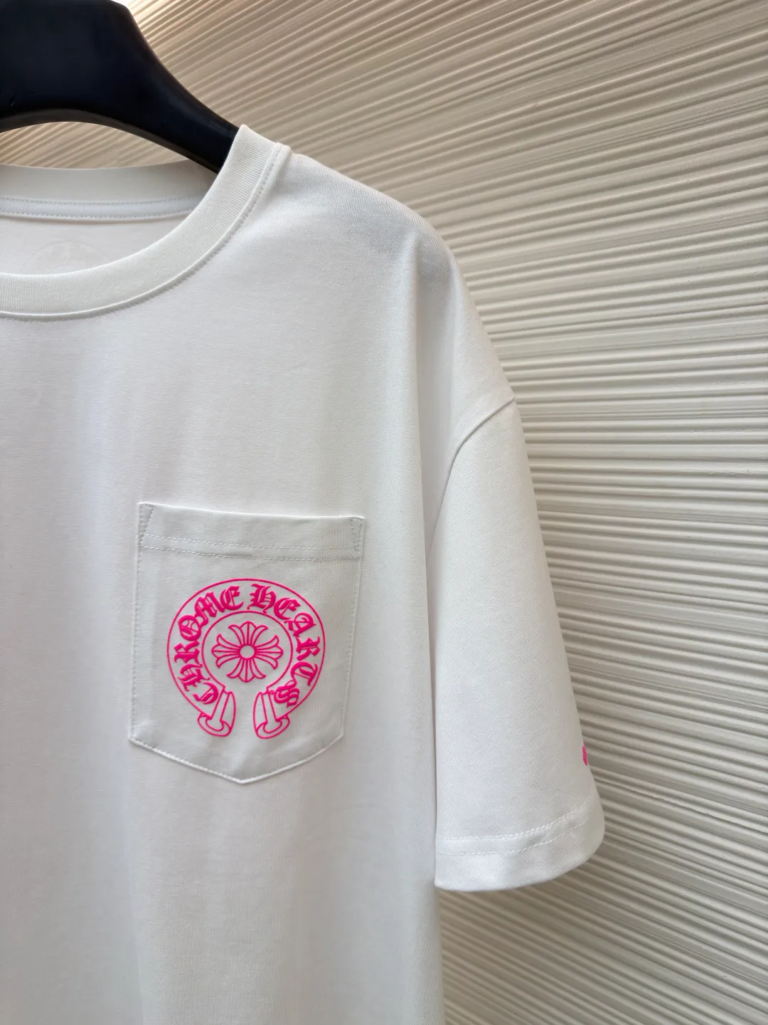 Chrome Hearts horseshoe pink T-shirt ●Item number: 1682507-X85 ●Fabric: cotton fabric ●Technology: hand-printed with ink ●Color: white ●Type: loose fit ●Weight: about 285 grams ●Size: S-M-L ●Description: This Chrome Hearts pocket printed short-sleeves are made of high-count double yarn cotton, with a weight of 320g. The fabric has been pre-washed to achieve a soft and skin-friendly touch. At the same time, it avoids shrinkage and fading problems from the root, and maintains a crisp shape after long-term wear. The body adopts seamless cylinder weaving technology, and there are no seams on the sides, so there is no sense of restraint when worn. The shoulders are classic dropped shoulders, and the loose body shape is suitable for all kinds of body shapes. The rose-red totem print on the left breast pocket is made of imported environmentally friendly slurry and produced through a high-precision screen printing process. The printing has clear layers and saturated colors, and it is not easy to crack or fall off after repeated washing. The neckline adopts a double-needle reinforced hemming design and is paired with a customized threaded collar, which is durable and not easily deformed. The overall wiring follows luxury craftsmanship standards, and the stitching is even and fine. Every detail demonstrates ingenuity. Customized hardware and accessories are complete with three logos, restoring the classic texture of the brand. The overall wiring is straight and delicate, the fabric is comfortable and soft, and the color is consistent without color difference. It can be matched with the same style to create a fashionable look and control various occasions. Customized accessories, complete with three standards, same style for men and women!